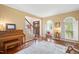 Inviting living room with wood floors, piano, arched windows, and staircase in the background at 8508 Kayenta Ct, Wake Forest, NC 27587