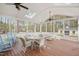 Relaxing screened-in patio with wooden floors, ceiling fan, wicker furniture, and blue rocking chairs at 8508 Kayenta Ct, Wake Forest, NC 27587