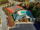 Aerial view of the community featuring tennis courts, a swimming pool, parking and a clubhouse surrounded by colorful trees at 915 Dunleigh Dr, Burlington, NC 27215