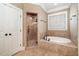 Bright bathroom featuring a walk-in shower and soaking tub under a window for a relaxing and functional space at 915 Dunleigh Dr, Burlington, NC 27215