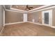 View of spacious bedroom featuring neutral tones, a tray ceiling with a ceiling fan, and a door to the outside at 915 Dunleigh Dr, Burlington, NC 27215