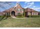 Stately stone and brick home with lush landscaping, showcasing curb appeal and architectural details at 915 Dunleigh Dr, Burlington, NC 27215