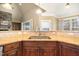 Kitchen sink with granite counters and tile backsplash, adjacent to the living room at 915 Dunleigh Dr, Burlington, NC 27215