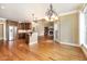 Spacious living area featuring hardwood floors, a kitchen, and a stone fireplace at 915 Dunleigh Dr, Burlington, NC 27215