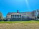 Expansive backyard view of the home featuring a screened-in porch and well-manicured lawn at 98 Lochridge Dr, Roxboro, NC 27573