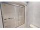 Bathroom features a shower with a sliding glass door and blue textured wallpaper at 98 Lochridge Dr, Roxboro, NC 27573