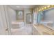 Bright bathroom featuring marble tile, jacuzzi tub and double vanity at 98 Lochridge Dr, Roxboro, NC 27573