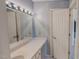 Well-lit bathroom featuring blue textured wallpaper, vanity with long mirror, and white painted doors at 98 Lochridge Dr, Roxboro, NC 27573