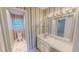Bathroom features a vanity, a large mirror with bulb lighting, and striped wallpaper design at 98 Lochridge Dr, Roxboro, NC 27573