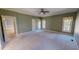 Large bedroom featuring light carpet and three windows with window treatments at 98 Lochridge Dr, Roxboro, NC 27573