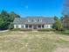Charming home featuring a welcoming front porch, well-manicured lawn, and lush landscaping at 98 Lochridge Dr, Roxboro, NC 27573