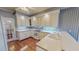 Bright kitchen with white cabinetry, modern appliances, and hardwood floors at 98 Lochridge Dr, Roxboro, NC 27573