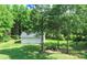 An outbuilding with multiple bays sits among mature trees and green grass at 98 Lochridge Dr, Roxboro, NC 27573