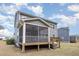 Backyard view of home featuring screened porch, deck, and grassy lawn at 104 Chaseford Ct, Holly Springs, NC 27540