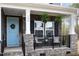 Inviting front porch with stone detail, hanging ferns, and cozy seating area offering curb appeal at 104 Chaseford Ct, Holly Springs, NC 27540