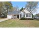 Charming single-story home boasts a well-manicured lawn, cozy front porch, and attached garage, perfect for suburban living at 105 Damask Rose Dr, Holly Springs, NC 27540