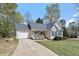 Quaint single-Gathering home featuring an attached garage, inviting front porch, and manicured landscaping for great curb appeal at 105 Damask Rose Dr, Holly Springs, NC 27540