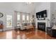 Cozy living room with hardwood floors, fireplace, and an abundance of natural light at 105 Damask Rose Dr, Holly Springs, NC 27540