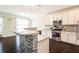 Bright kitchen featuring white cabinets and a breakfast bar with tile accents at 1102 Dartmouth Dr, Mebane, NC 27302