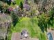 An aerial view of a large green backyard with a deck and surrounding mature trees at 11129 Bayberry Hills Dr, Raleigh, NC 27617