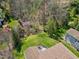 Aerial view of a lush backyard with a deck and trees, including one with purple blossoms at 11129 Bayberry Hills Dr, Raleigh, NC 27617