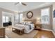 This primary bedroom boasts a tray ceiling, warm hardwood floors, and a decorative round mirror at 11129 Bayberry Hills Dr, Raleigh, NC 27617