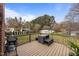 Wooden deck with wicker seating, grill and lush backyard views with storage shed at 1208 Briarcliff Rd, Burlington, NC 27215