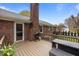 Brick home featuring a deck, grill, and lush backyard at 1208 Briarcliff Rd, Burlington, NC 27215