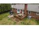 Brick home featuring a cozy wooden deck and flourishing garden beds in a well-manicured backyard at 1208 Briarcliff Rd, Burlington, NC 27215