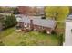 Brick home boasts a wooden deck, garden beds, and trampoline in expansive backyard at 1208 Briarcliff Rd, Burlington, NC 27215