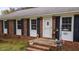 Charming front porch with flowers creates inviting entry into brick home at 1208 Briarcliff Rd, Burlington, NC 27215