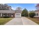 Brick home featuring an attached garage and long driveway, perfect for parking at 1208 Briarcliff Rd, Burlington, NC 27215