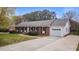 Classic brick home featuring an attached garage, long driveway, and well-manicured lawn at 1208 Briarcliff Rd, Burlington, NC 27215