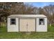 Storage shed in backyard with double doors and windows providing ample backyard storage at 1208 Briarcliff Rd, Burlington, NC 27215