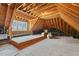 Unfinished attic space showcasing exposed wood framing and a large window at 121 Highclere Ln, Cary, NC 27518