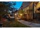 This backyard features a stone patio, manicured lawn, and professionally designed lighting at 121 Highclere Ln, Cary, NC 27518