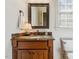 Bathroom featuring a wood vanity, marble countertops, decorative mirror, and window for natural light at 121 Highclere Ln, Cary, NC 27518