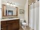 Well-lit bathroom featuring a granite countertop, dark wood cabinets, and a large framed mirror at 121 Highclere Ln, Cary, NC 27518