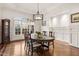 Elegant dining area with hardwood floors, wainscoting, and backyard views at 121 Highclere Ln, Cary, NC 27518