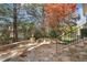 Stylish stone patio with a built-in fire pit, surrounding stone seating, and landscaped yard at 121 Highclere Ln, Cary, NC 27518