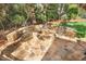 Stone fire pit with chairs on a stone patio, perfect for outdoor entertaining in landscaped backyard at 121 Highclere Ln, Cary, NC 27518