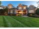 A beautifully designed home with a manicured lawn, stone facade, and a welcoming front porch at 121 Highclere Ln, Cary, NC 27518