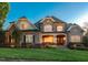 Charming two-story brick and stone home at dusk with warm interior lights at 121 Highclere Ln, Cary, NC 27518