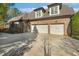 Elegant brick home featuring a three-car garage with white doors and a spacious driveway at 121 Highclere Ln, Cary, NC 27518