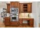 Kitchen area with stainless steel appliances, custom wood cabinets, and a built-in desk at 121 Highclere Ln, Cary, NC 27518