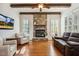 Comfortable living room with stone fireplace, wood beam ceiling, plantation shutters, and hardwood floors at 121 Highclere Ln, Cary, NC 27518