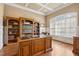 Spacious office with custom built-in bookshelves, hardwood floors, coffered ceilings, and natural light at 121 Highclere Ln, Cary, NC 27518