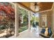 Relaxing covered porch with seating, decorative columns, ceiling fan, and backyard views at 121 Highclere Ln, Cary, NC 27518