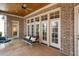 Covered back porch with a ceiling fan, exposed brick, and comfortable seating with plush pillows at 121 Highclere Ln, Cary, NC 27518