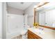 Cozy bathroom featuring a shower-tub combo, wood-framed mirror, and oak vanity at 124 Ripley Ct, Cary, NC 27513